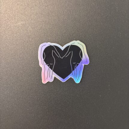 Sticker Love is Love représentant deux silhouettes féminines se faisant face à l'intérieur d'un cœur aux couleurs inspirées du drapeau lesbien.