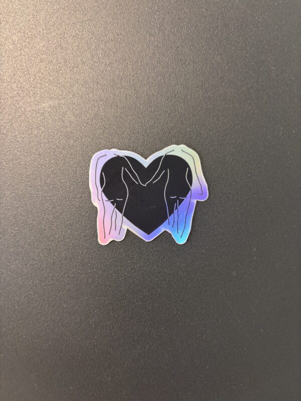 Sticker Love is Love représentant deux silhouettes féminines se faisant face à l'intérieur d'un cœur aux couleurs inspirées du drapeau lesbien.